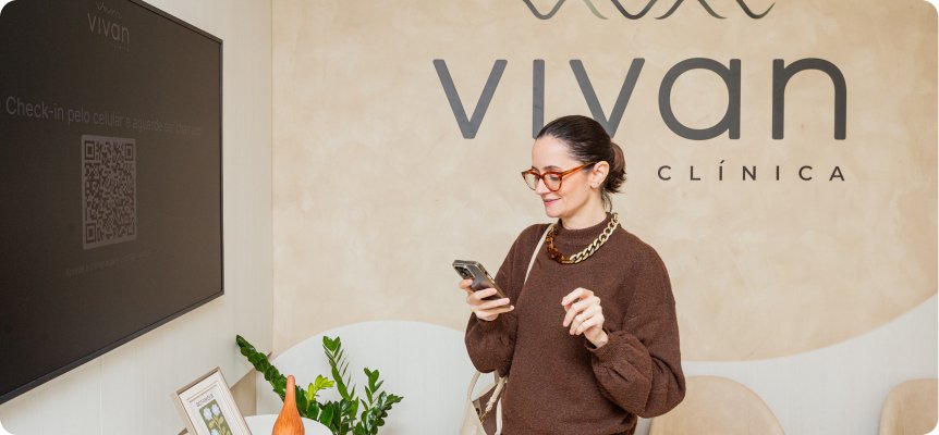 Médica fazendo check-in pelo celular na recepção da Vivan